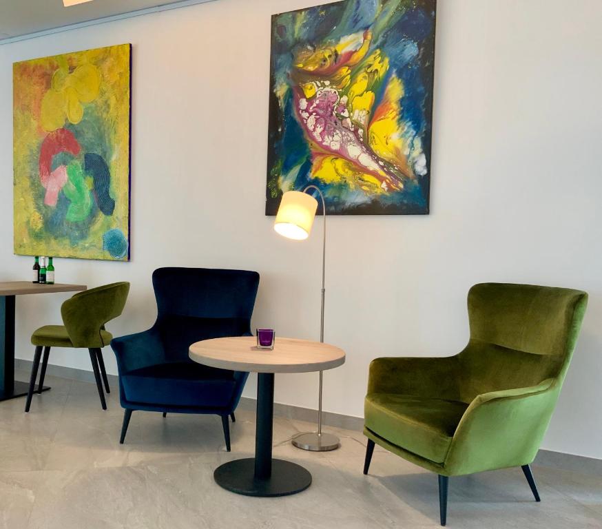 a room with chairs and a table and a painting at StadtHotel ARTE in Remagen