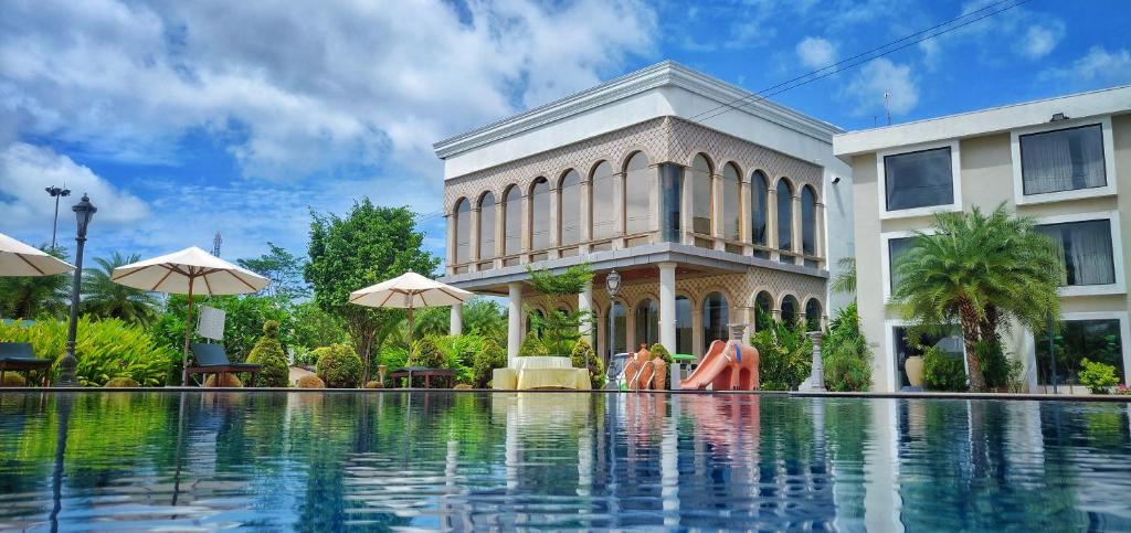 un edificio con piscina frente a un edificio en UVA Meridian Bay Resort & Spa, en Kundapur