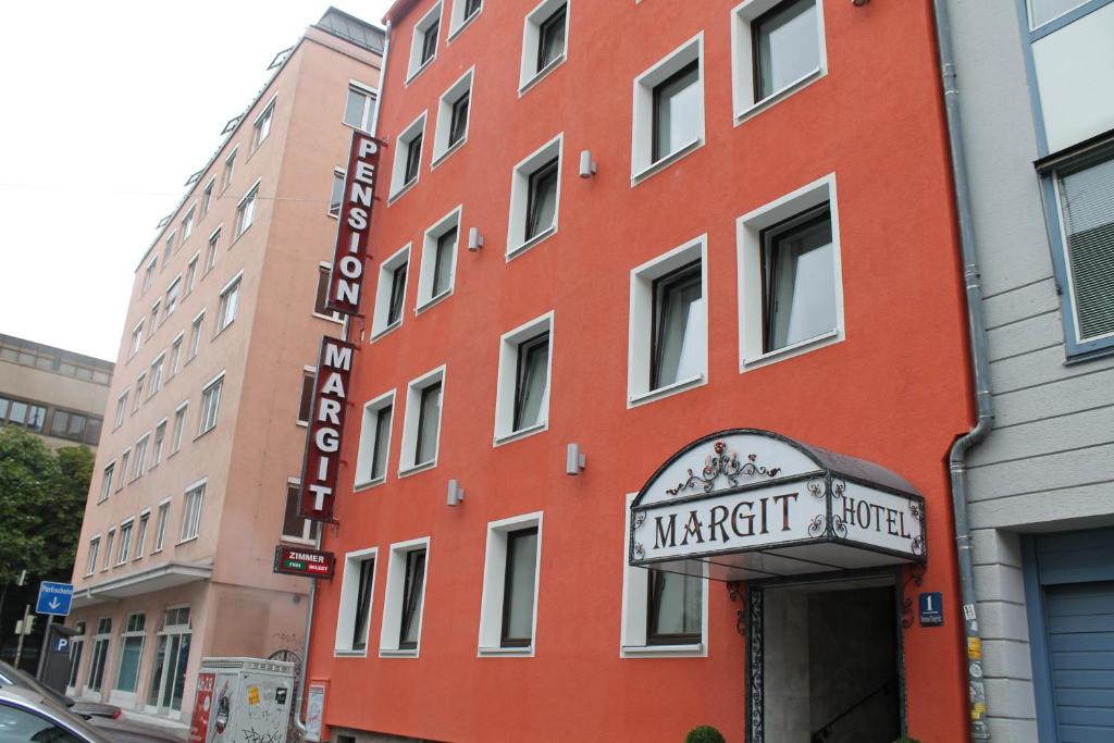 um edifício vermelho com uma placa para um hotel Marriott em Hotel Margit em Munique