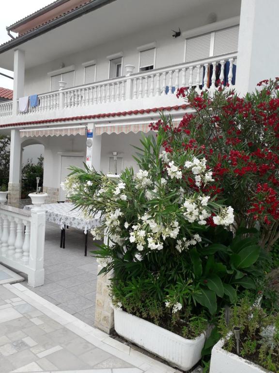 a house with flowers in front of it at Lovely Marjetka apartment in Rab