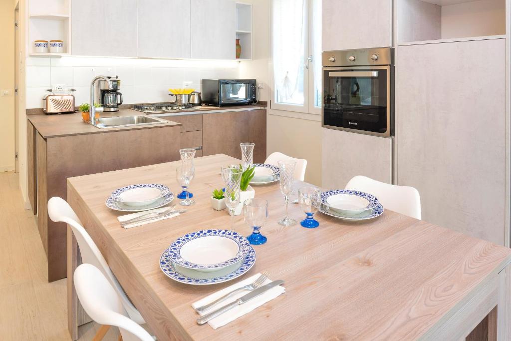 een houten tafel met borden en glazen in de keuken bij Family house Bivio in Peschiera del Garda