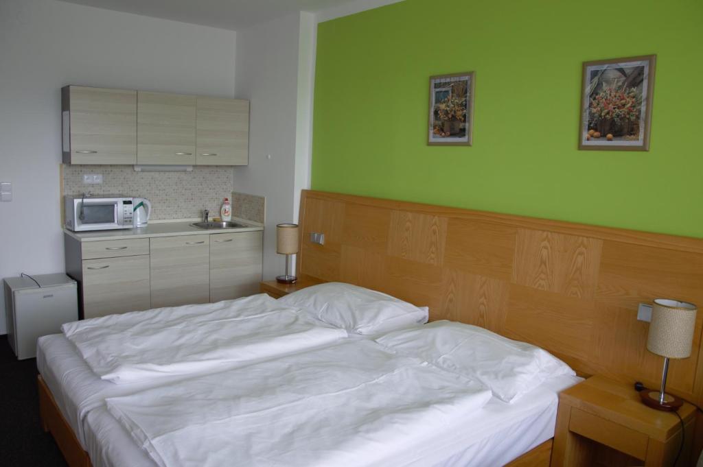 フリンブルクにあるApartmány Wellness Holiday Frymburkの緑の壁のベッドルーム1室(白いベッド1台付)