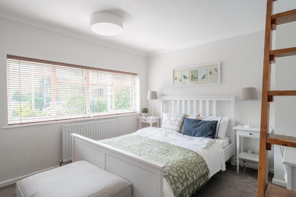 a white bedroom with a bed and a window at Henley self catering House in Henley on Thames