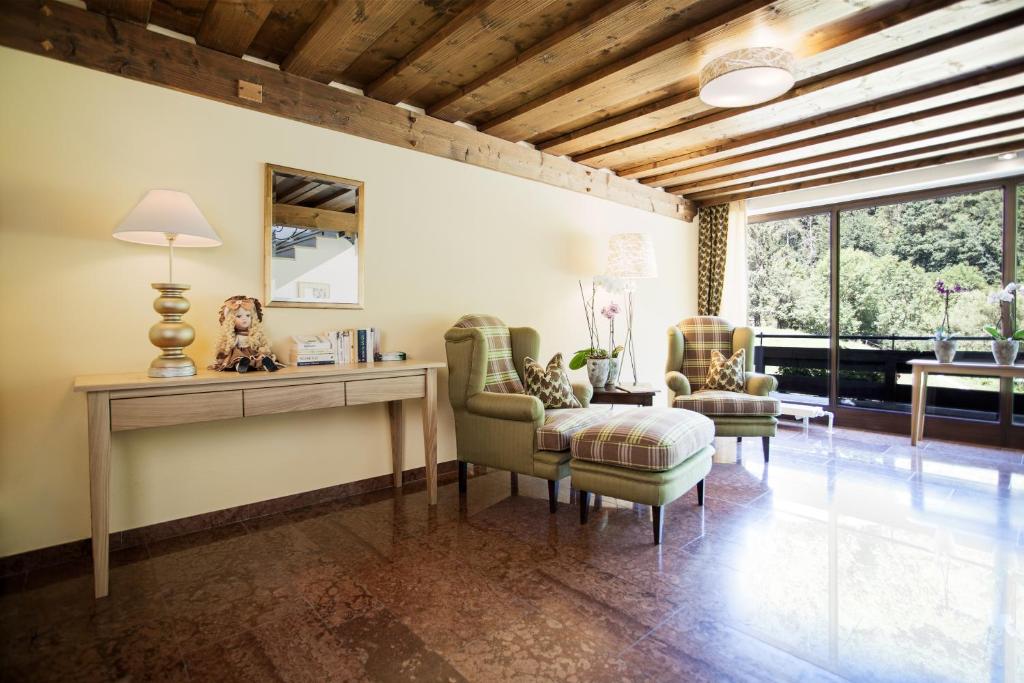 a living room with a table and two chairs at Hotel Seewinkel in Fuschl am See