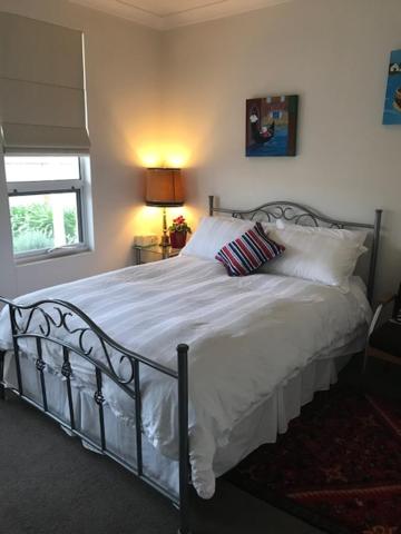 a bedroom with a bed with white sheets and pillows at Not quite the Ritz in West Richmond