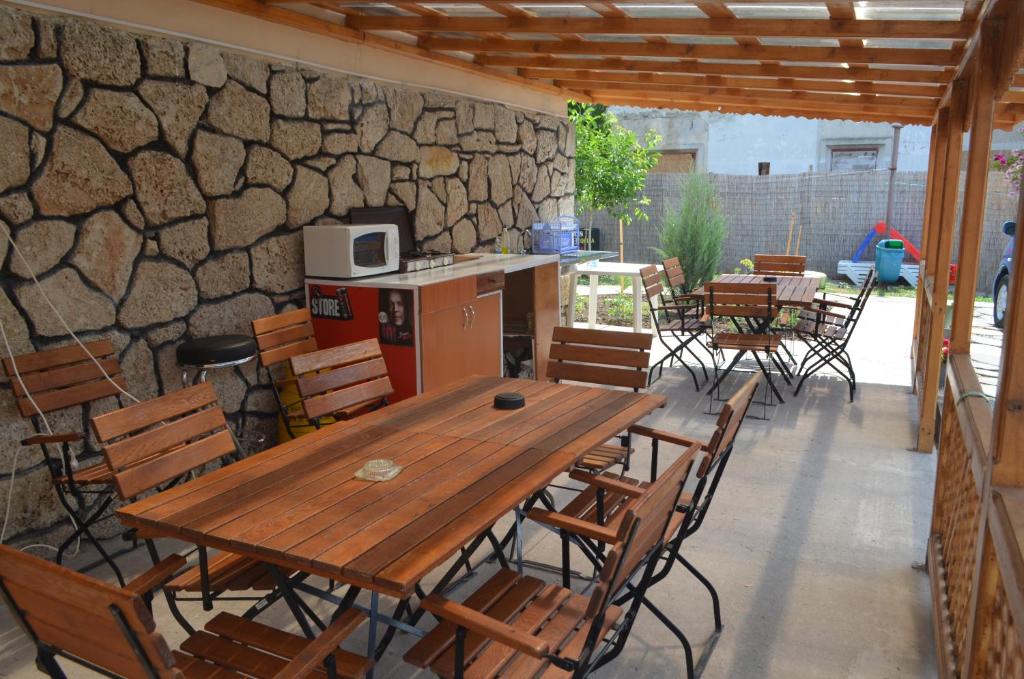 a patio with a wooden table and chairs and a stone wall at Complex Minerva in Costinesti