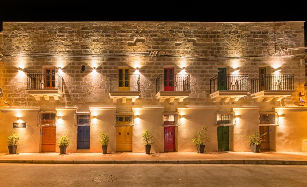 eine Fassade eines Gebäudes in der Nacht mit Lichtern in der Unterkunft Quayside Apartments in Marsaxlokk