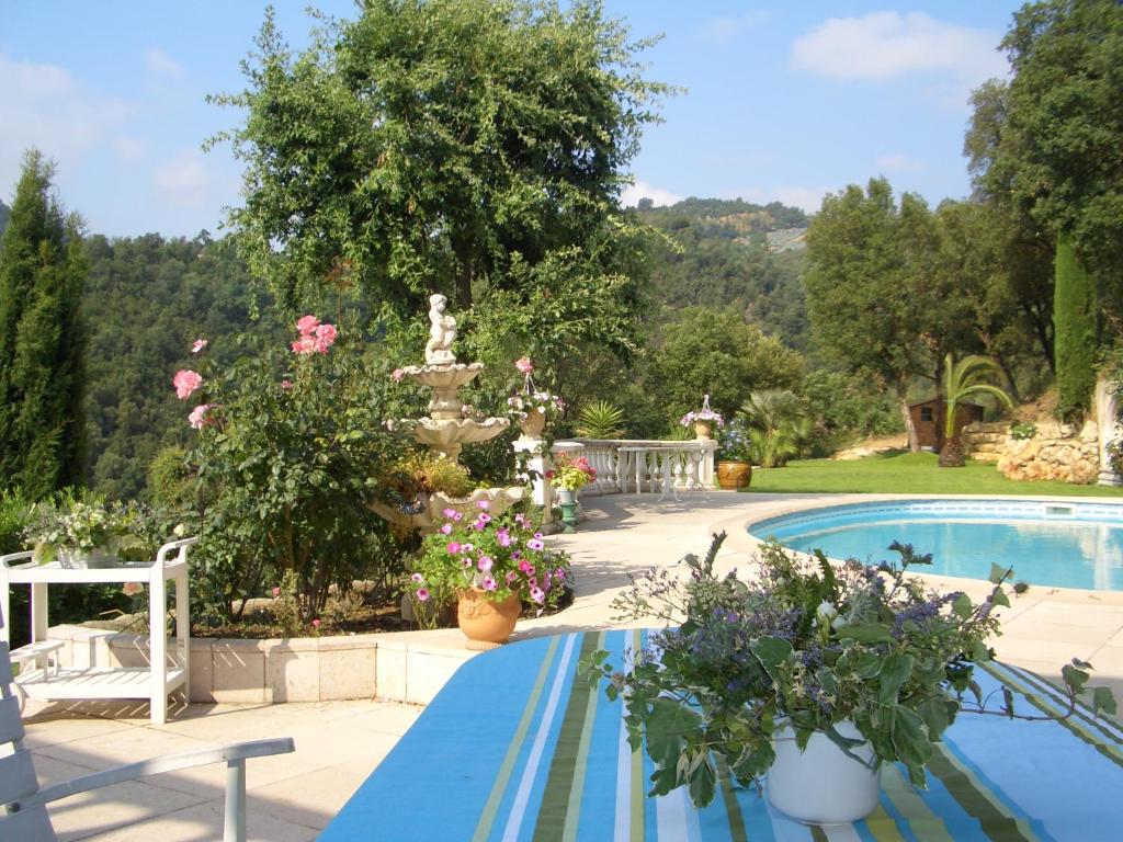- une piscine avec des fleurs et une fontaine dans l'établissement La Grimaudière, à Auribeau-sur-Siagne