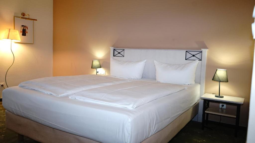 Postel nebo postele na pokoji v ubytování Entrée Groß Borstel Garni Hotel