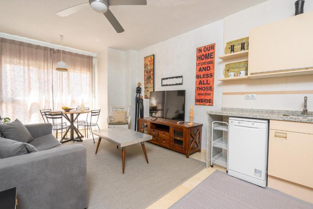 cocina y sala de estar con sofá y mesa en Turistic Home 4-Attic, en Málaga