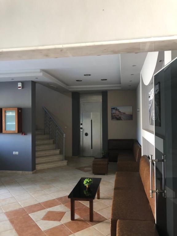 a lobby with stairs and a table with a plant on it at Villa Un bel posto Sea View in Nea Vrasna