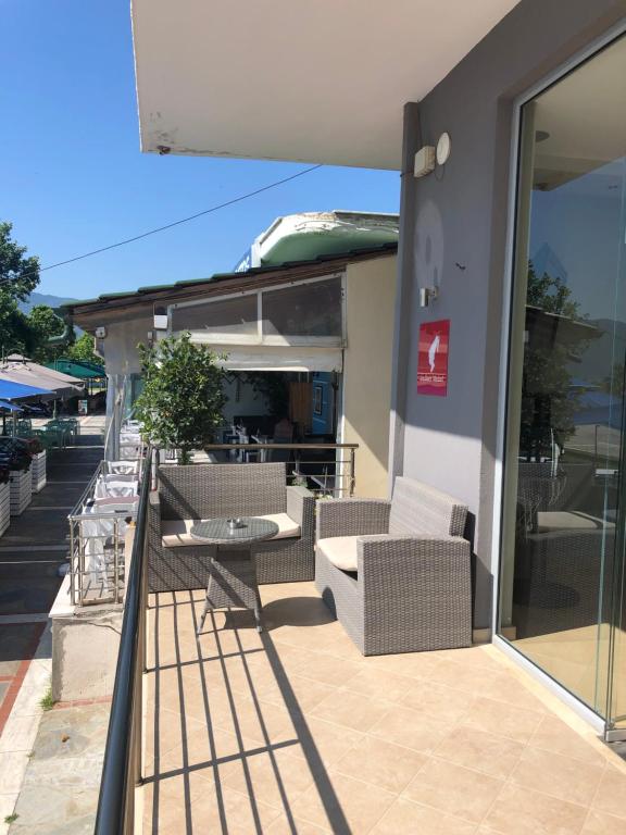 a patio with chairs and a table on a balcony at Villa Un bel posto Sea View in Nea Vrasna