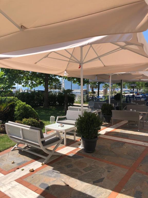 a patio with two chairs and an umbrella at Villa Un bel posto Sea View in Nea Vrasna