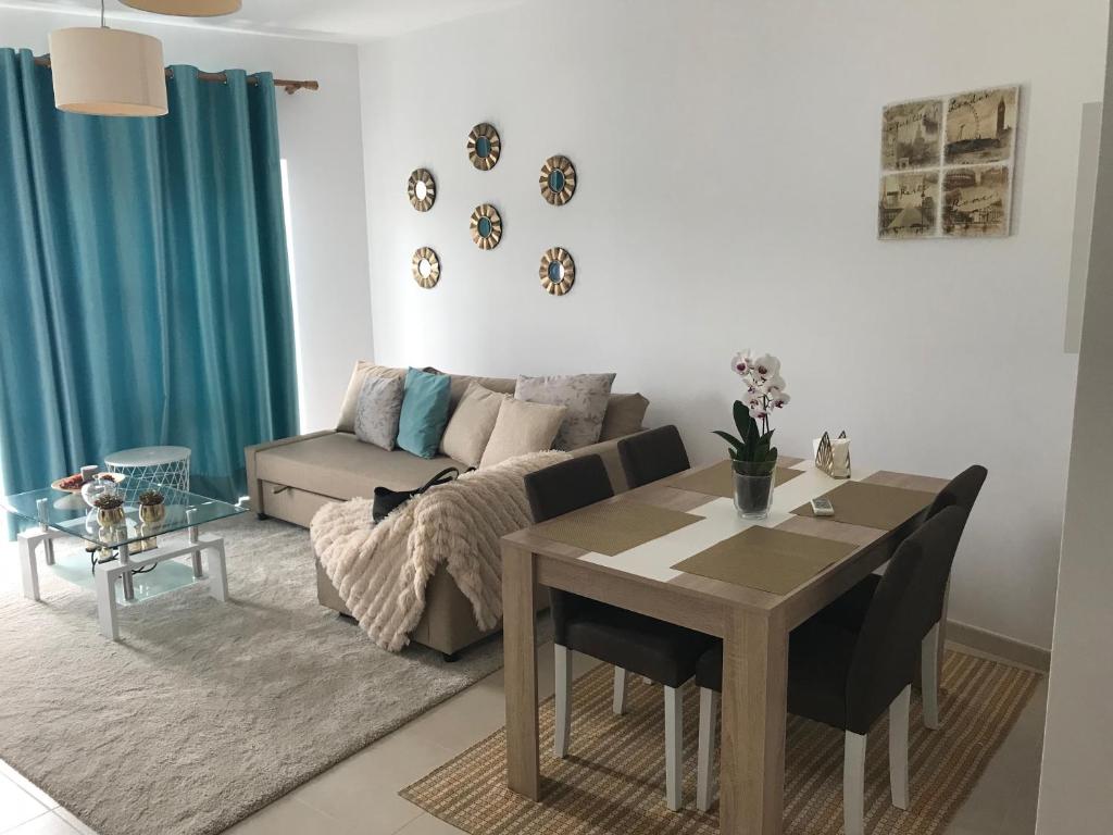 a living room with a table and a couch at Prazeres do Golf in Quinta do Anjo