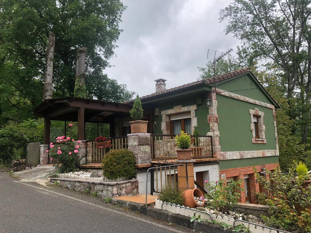 a green house with a balcony on a street at La Mermellina, 22 in Arriondas