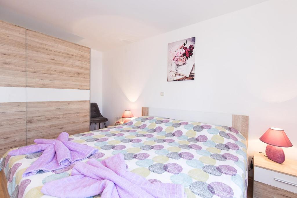 a bedroom with a bed with a purple blanket on it at Apartment Adrijana in Vrbnik