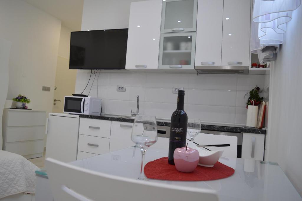 Una botella de vino y dos vasos en una barra de cocina en Apartments Luce - Dome, en Split