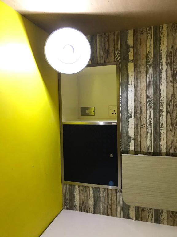 a bathroom with a mirror and a yellow wall at Hive Bed and Backpacker蜂巢膠囊旅店 in Hualien City