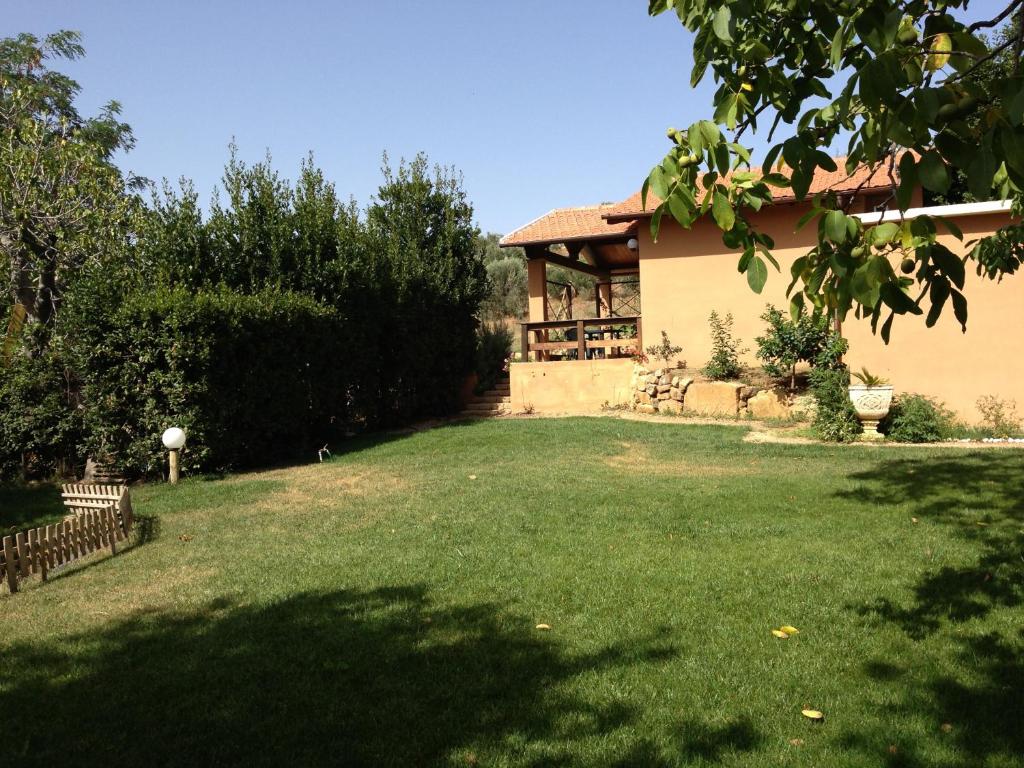 une maison avec une grande pelouse devant elle dans l'établissement Agriturismo San Mauro, à Capalbio