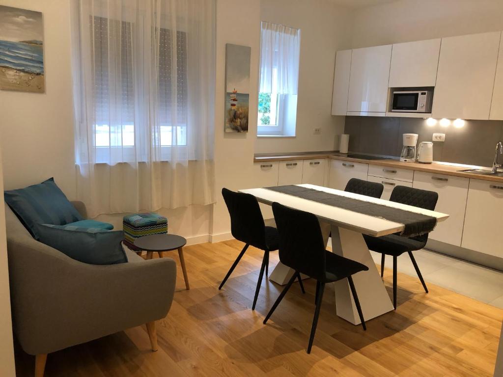 uma cozinha e sala de estar com mesa e cadeiras em Tempus Apartment em Split