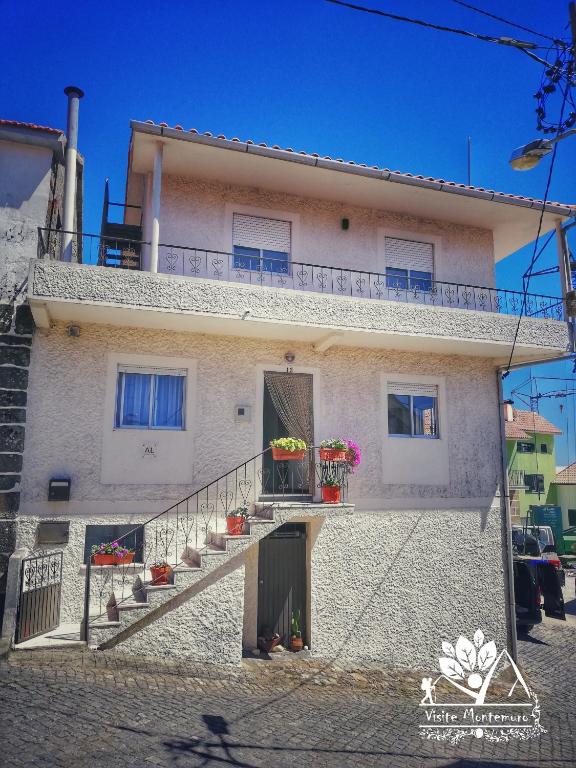 a white house with stairs and flowers on it at Casa Esperança in Castro Daire