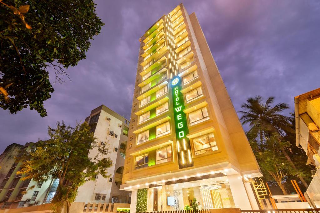 a tall building with a green sign on it at Hotel Wego in Mumbai