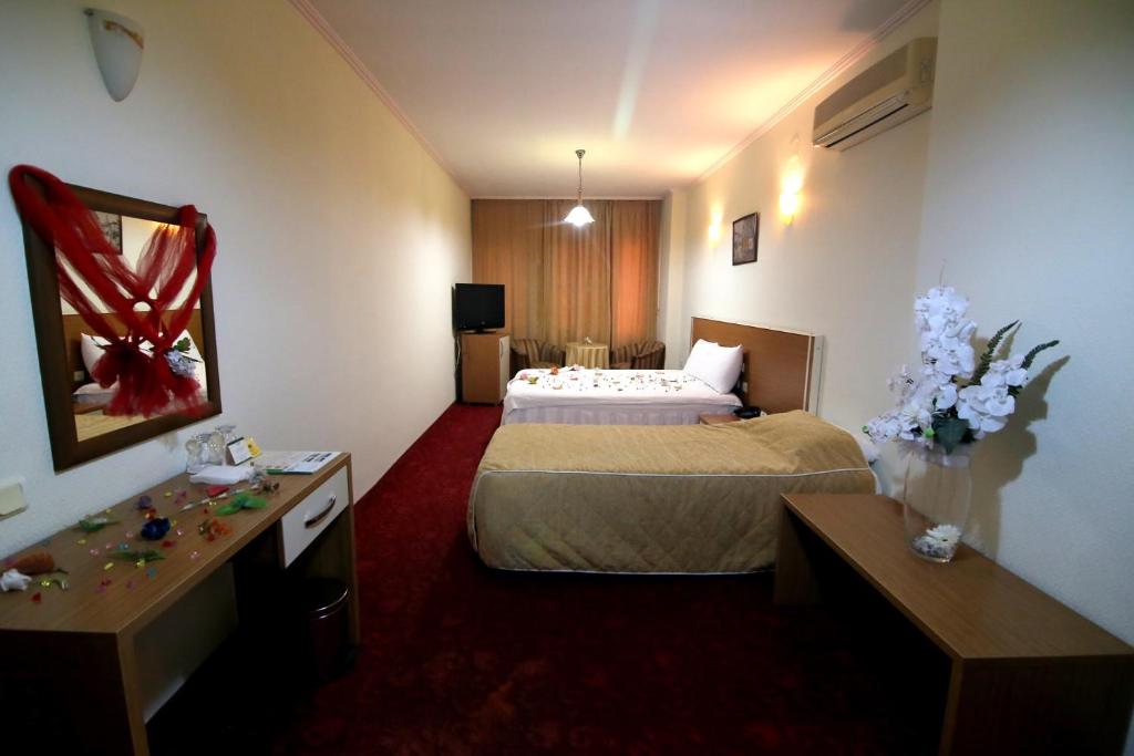 a hotel room with two beds and a desk at Aykut Palace Otel in İskenderun