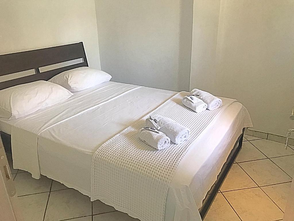 una camera da letto con un letto con due asciugamani sopra di Alex Flat a Néoi Epivátai