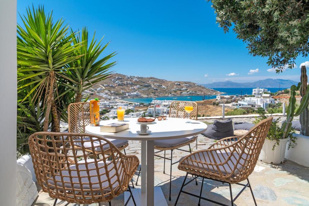 a table and chairs with a view of the ocean at Ornos Blue in Ornos