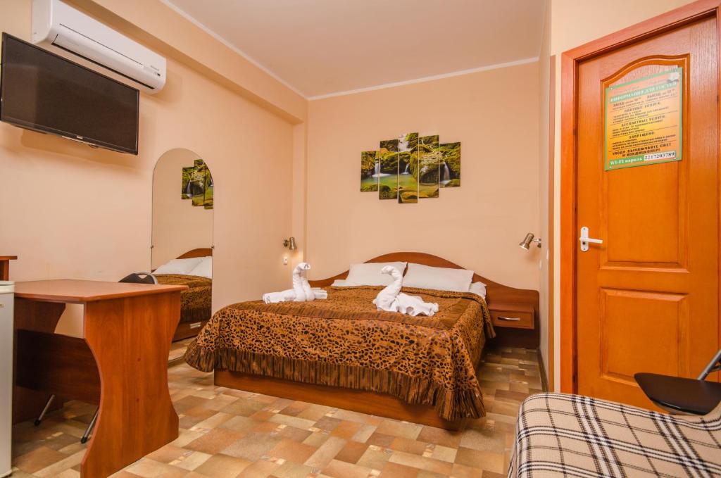 a hotel room with a bed with two animals on it at Гостевой дом Рыжий Кот (Людмила) in Alushta