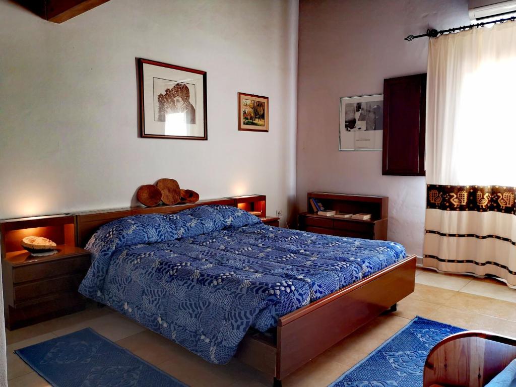a bedroom with a bed with a teddy bear on it at S'Abba Druche rooms in Bosa