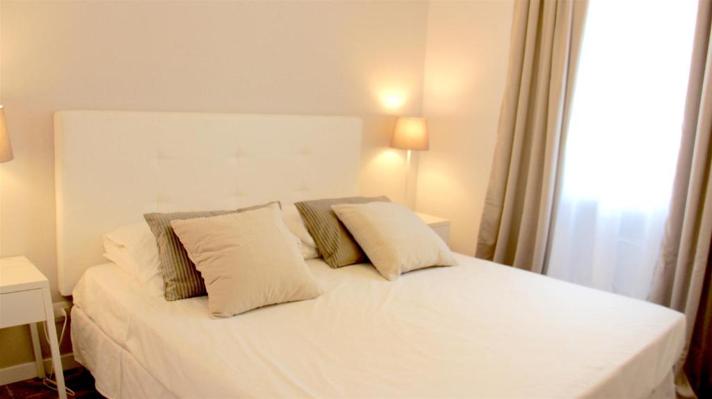 una camera con un letto bianco con due cuscini di Villa Italia - Marina di Lesina a Lesina