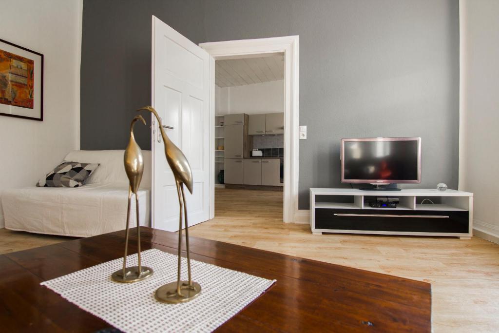 a living room with a television and a statue at Ferienwohnung „Markus“ in Bad Ems