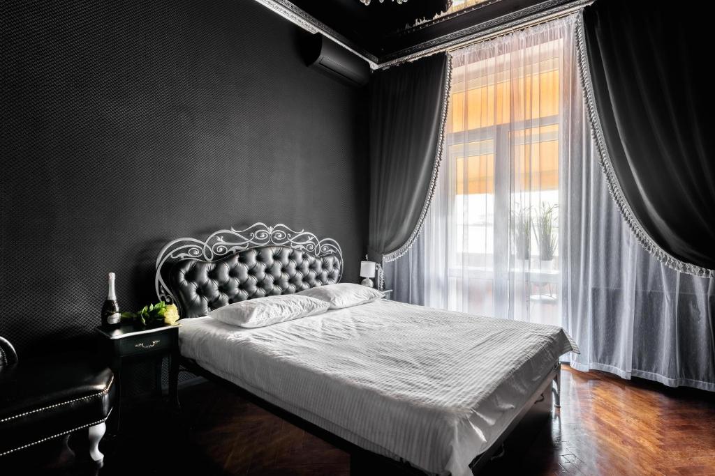 ein Schlafzimmer mit einem Bett und einem großen Fenster in der Unterkunft Apartment Secret Place in Lwiw