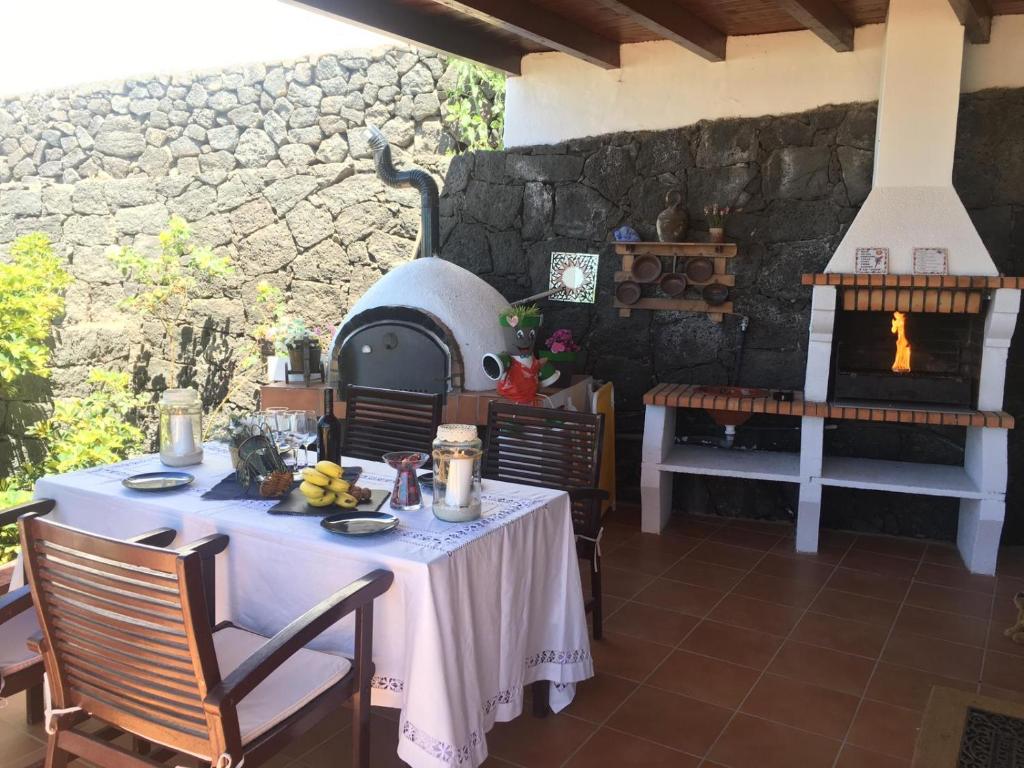 a dining room with a table and an outdoor oven at Casa Gloria in Tías