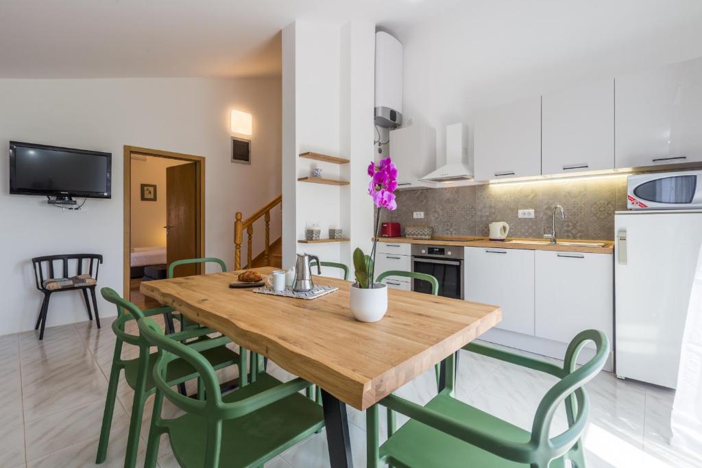 una cucina e una sala da pranzo con tavolo e sedie in legno di Apartment Lungera a Pola (Pula)