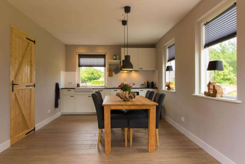 een keuken en eetkamer met een houten tafel en stoelen bij Bed & Breakfast Bos en Weide in Boxtel