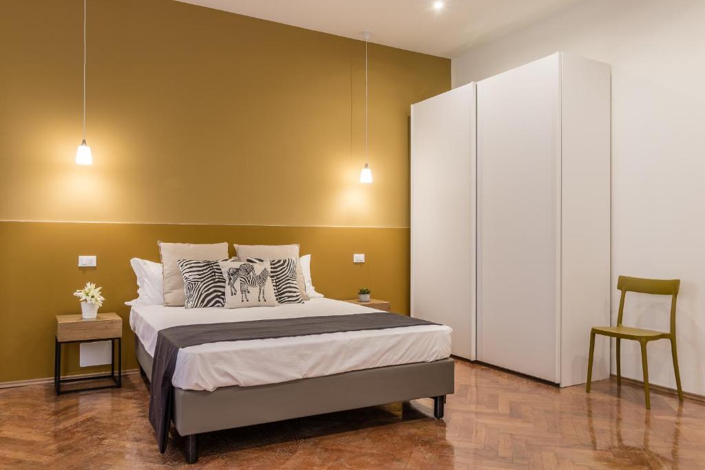 una camera con un letto e una parete gialla di Elegante appartamento da 6 Blu&Oro a Trieste