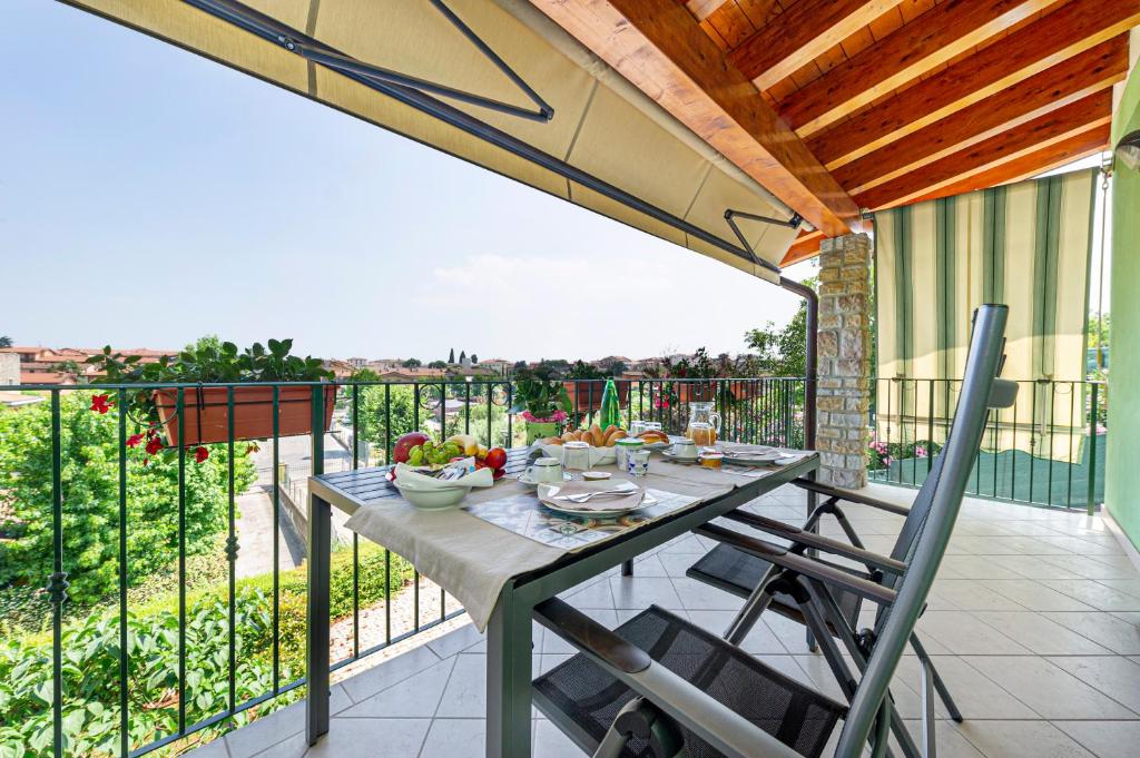 eine Terrasse mit einem Tisch und Stühlen auf dem Balkon in der Unterkunft B&B Casa Paola in Moniga
