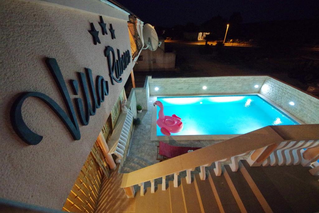 widok na basen w nocy w obiekcie Villa Rubesco w mieście Sikovo