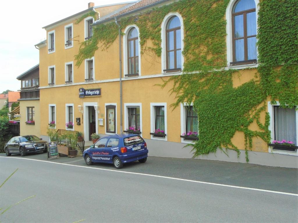 a blue car parked in front of a yellow building at Erbgericht in Bad Schandau