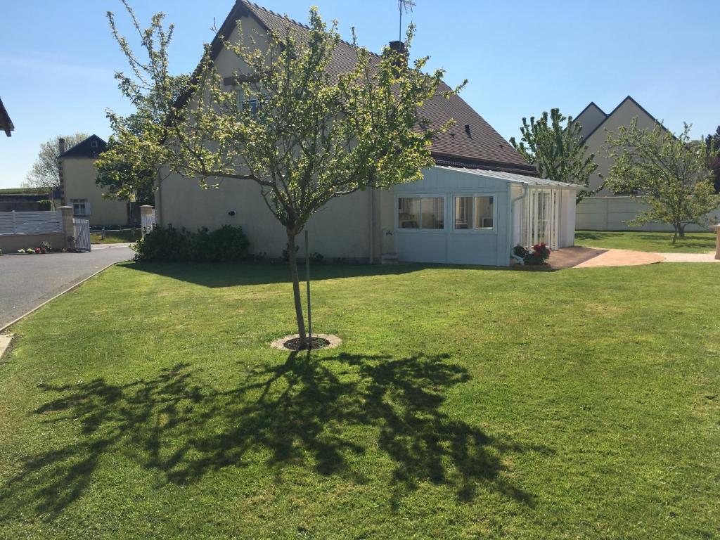 a tree in the grass in front of a house at B&B de Saint Come de Fresné in Saint-Côme-de-Fresné