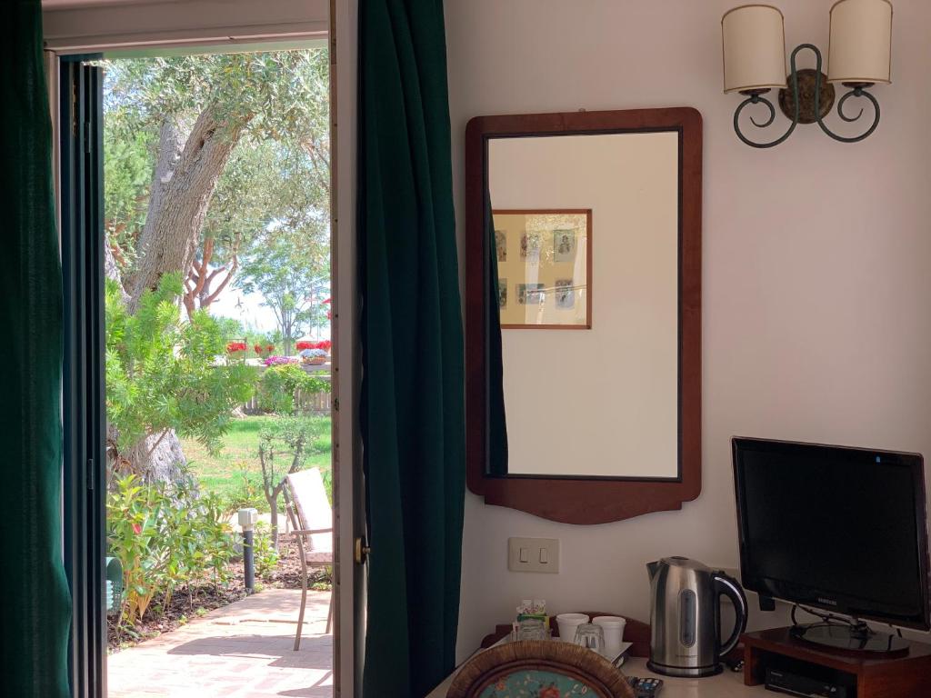 a mirror and a television in a room with a window at Villino Eleonora in Parghelia