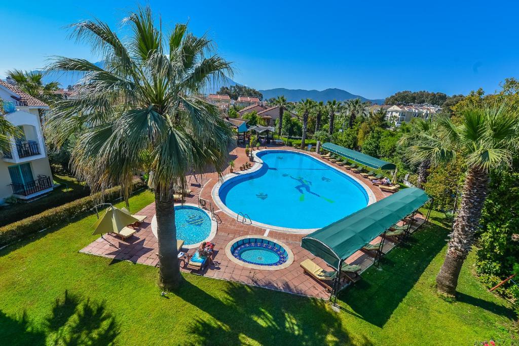 een uitzicht over een zwembad met palmbomen bij Rebin Beach Hotel in Fethiye