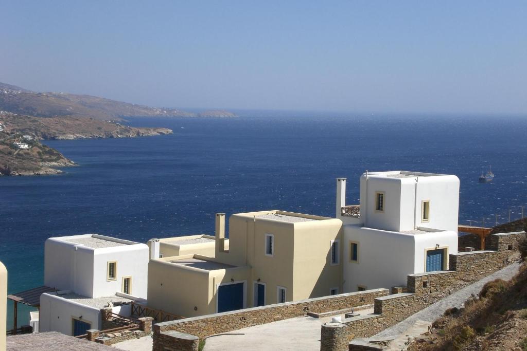 a group of white buildings on a cliff with the ocean at Monolithos Villas in Kipri
