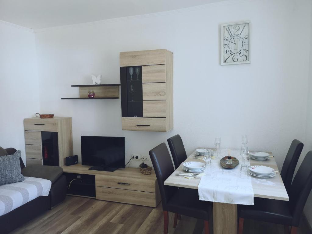 a dining room with a table with chairs and a couch at APP EMONA in Bašanija