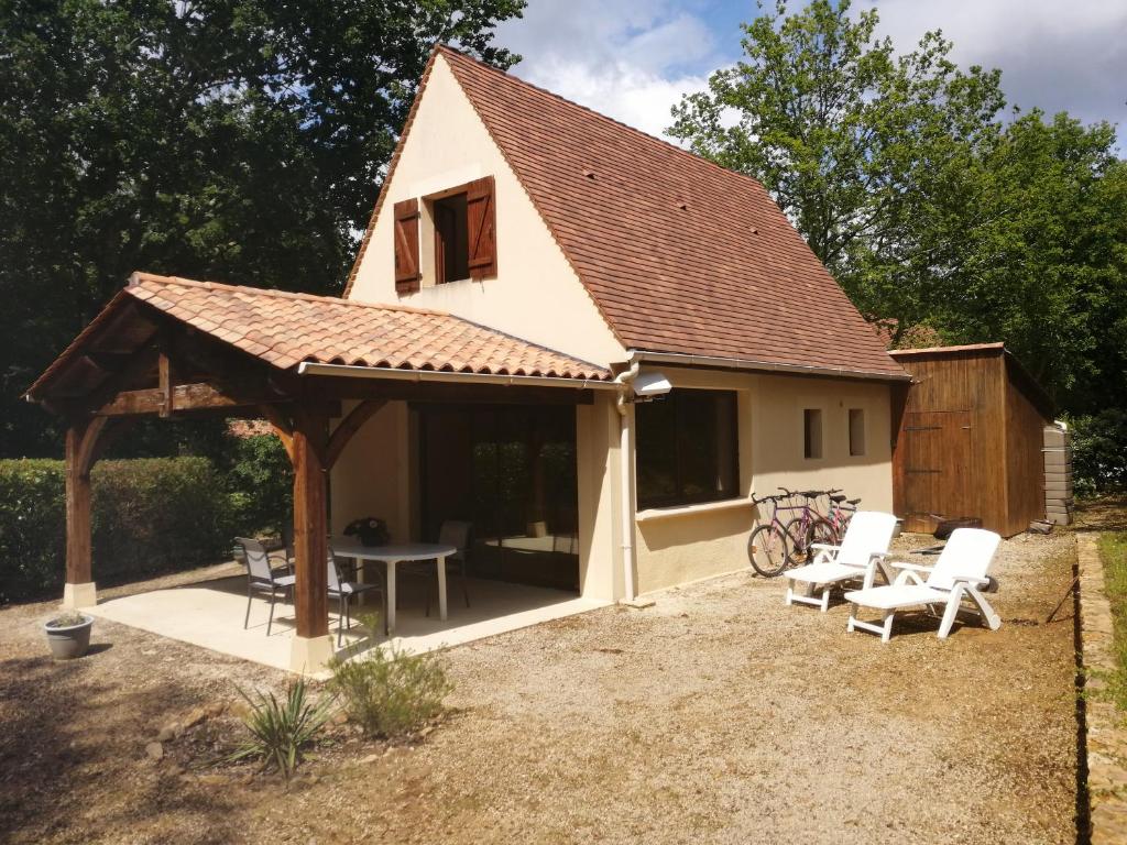 um pavilhão com uma mesa e cadeiras num quintal em Le Pech de Sireuil em Groléjac