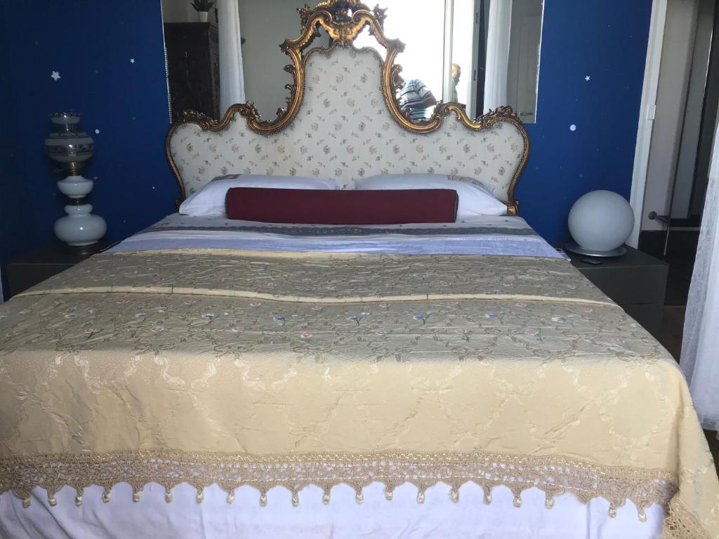 un letto in una camera blu con una grande testiera del letto di Appartamento Vista Mare Regina Elena al Porto a Trapani