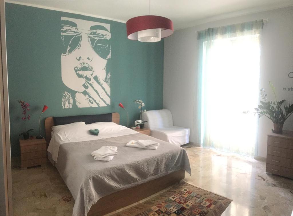 una camera da letto con un letto e un dipinto di una donna di I Giardini di Villa Giulia a Palermo