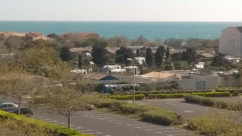 uitzicht op een parkeerplaats met de oceaan op de achtergrond bij residence du mail in Cap d'Agde